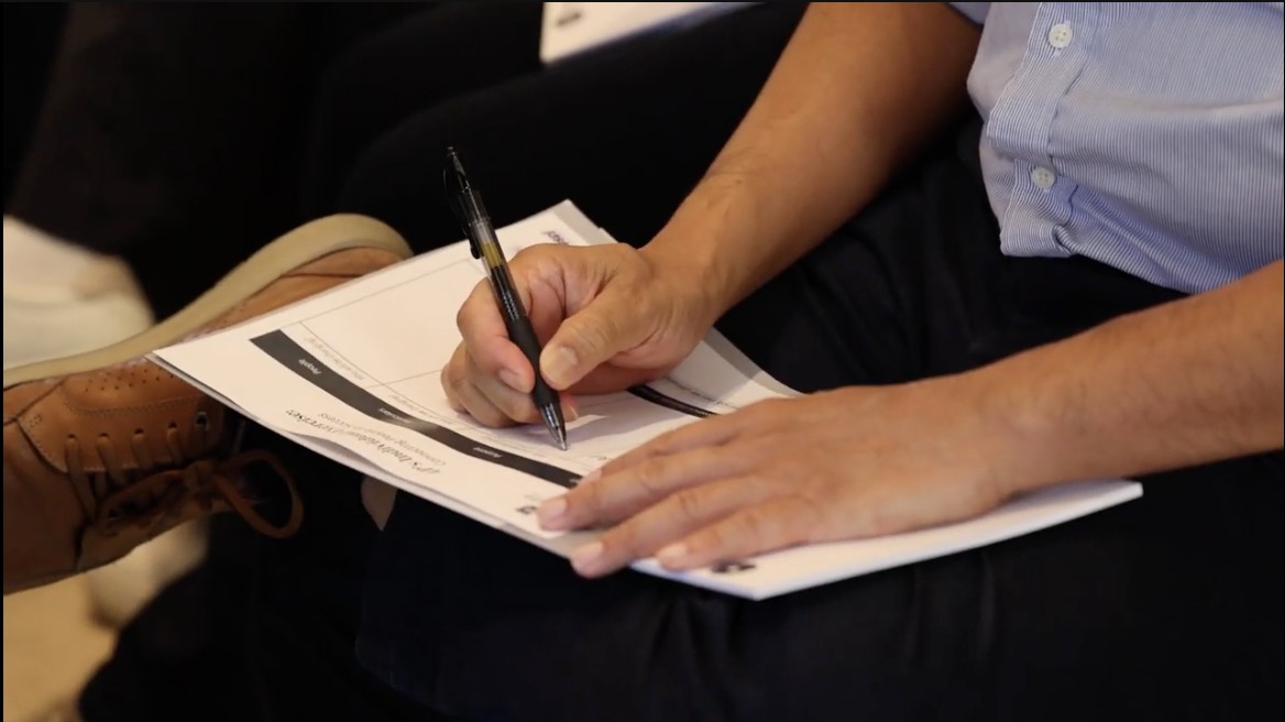 A participant taking notes on a worksheet during an offsite