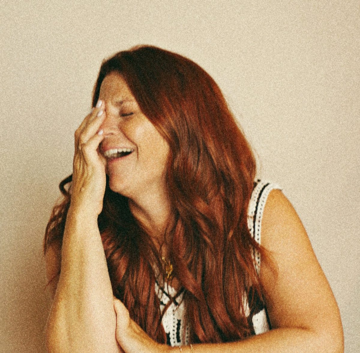 Kristen Day laughing with her hand over her face