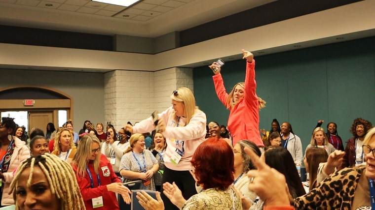 A room full of early childhood educators cheering during one of Kristen's keynotes
