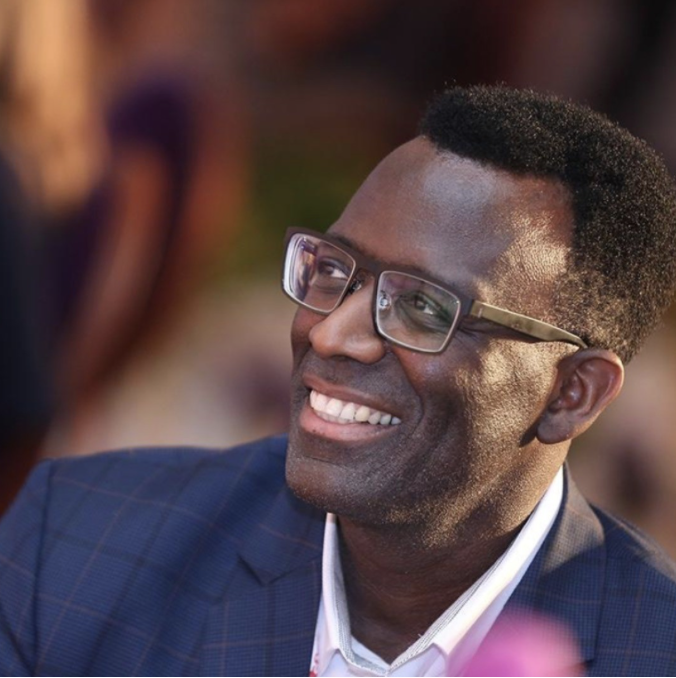 Terry J Lewis smiling in a navy velvet jacket and bow tie