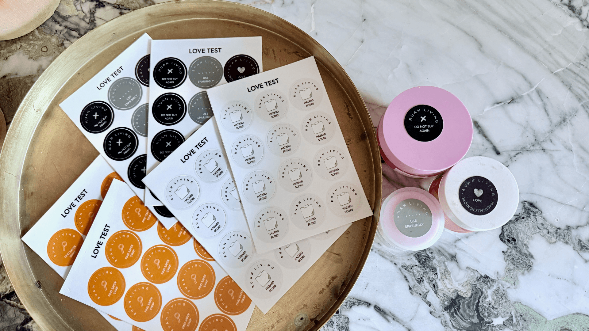 Love Test Detox Sticker Sheets on a brass circular tray with three products with stickers: Do Not Buy Again, Love, and Use Sparingly
