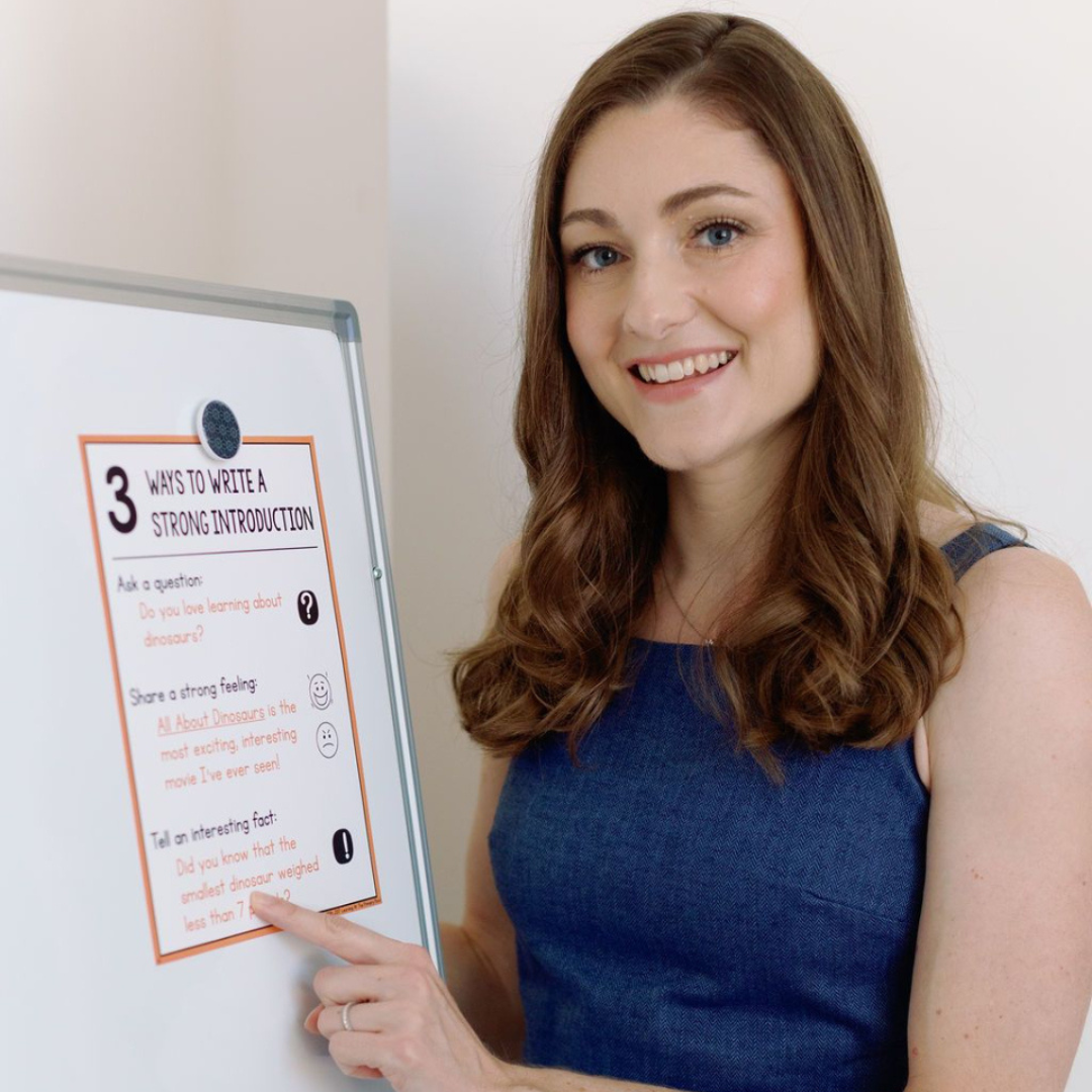Alison Ryan sitting in a classroom with a white board and set of magnetic letters, placing the 