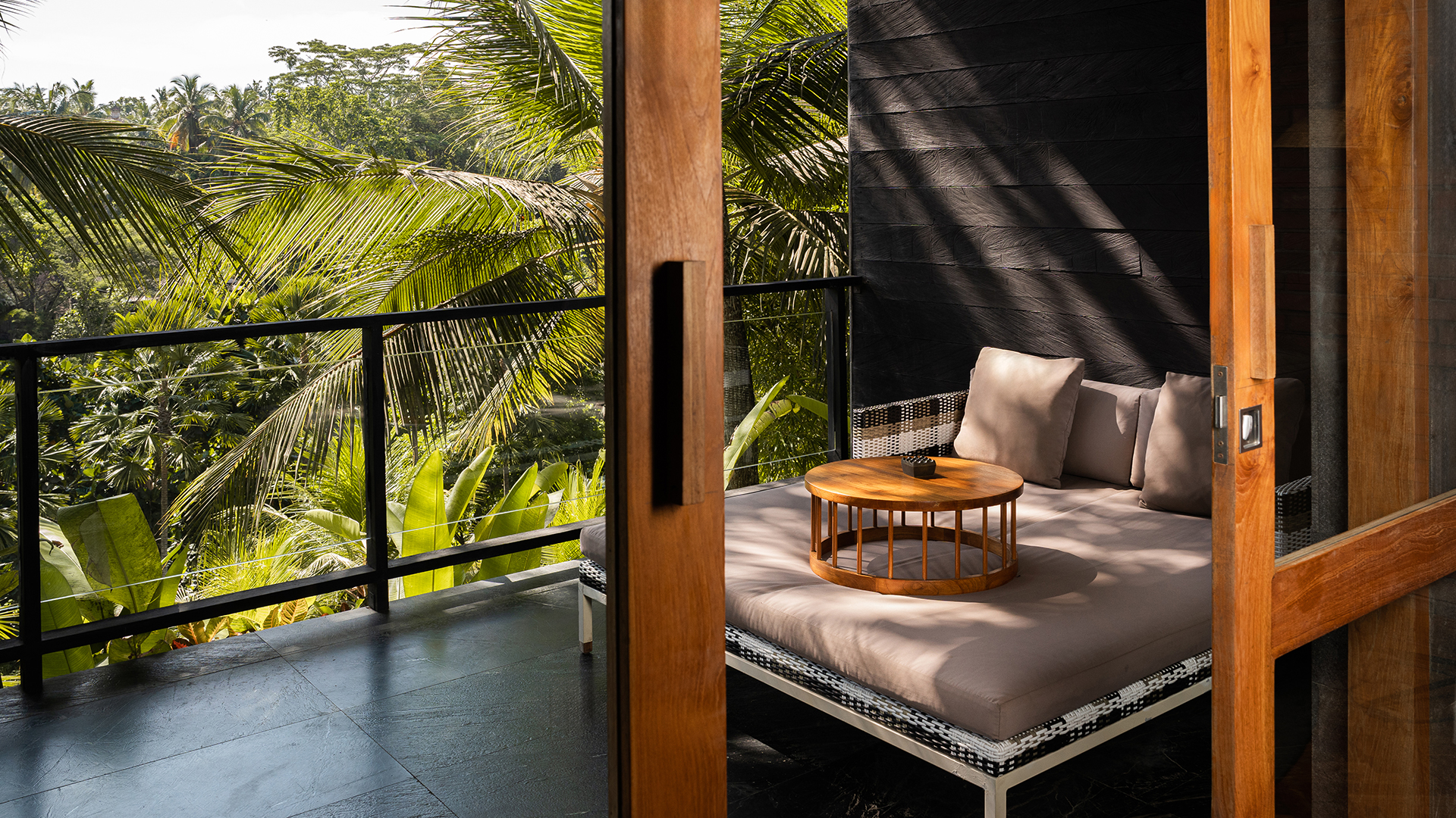 Deluxe Pool Suite balcony with a daybed and tropical views