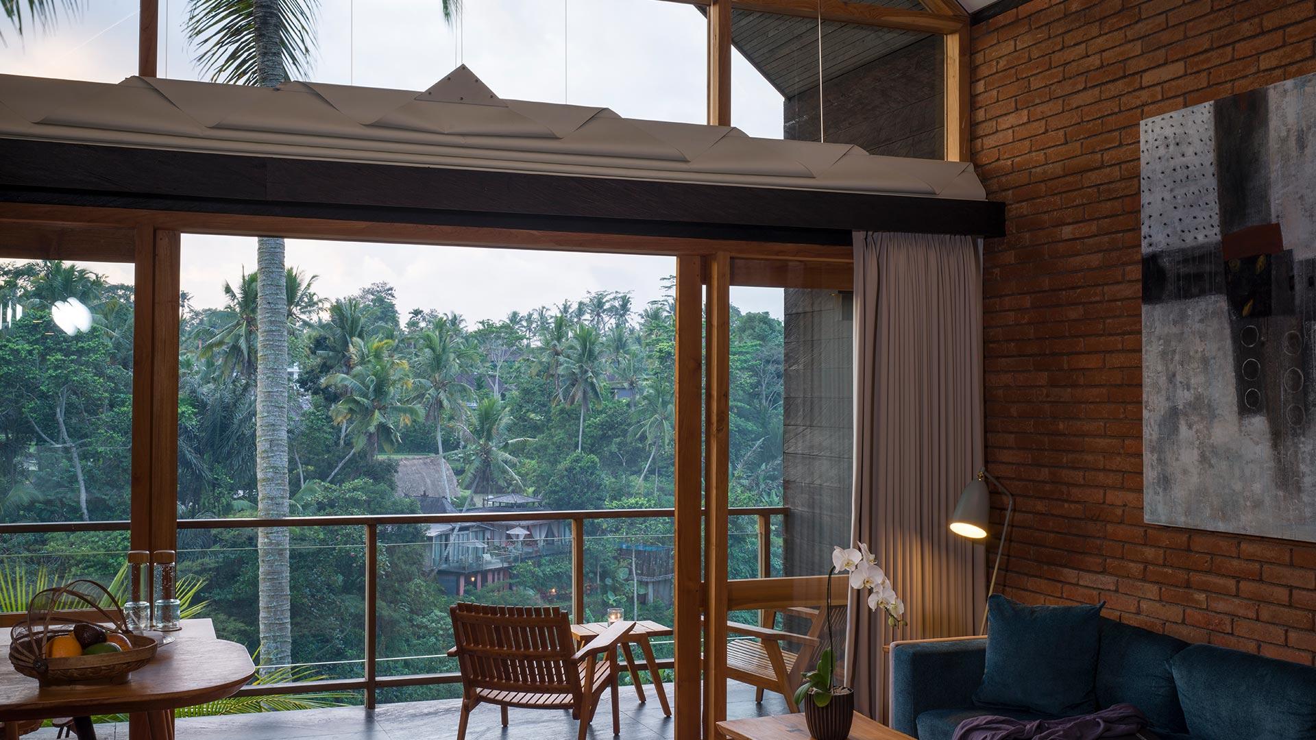 Deluxe Suite sitting area and balcony overlooking the greenery