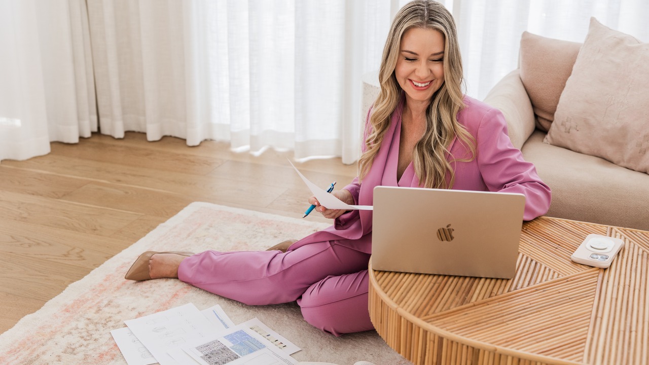 Jodie Minto ecommerce coach reviewing Meta ads strategy with laptop and documents