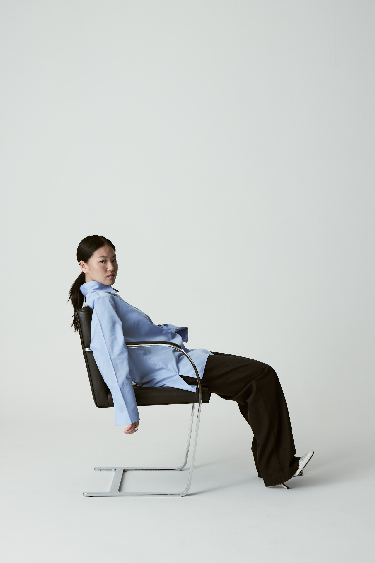 Woman lounging in a modern chrome chair