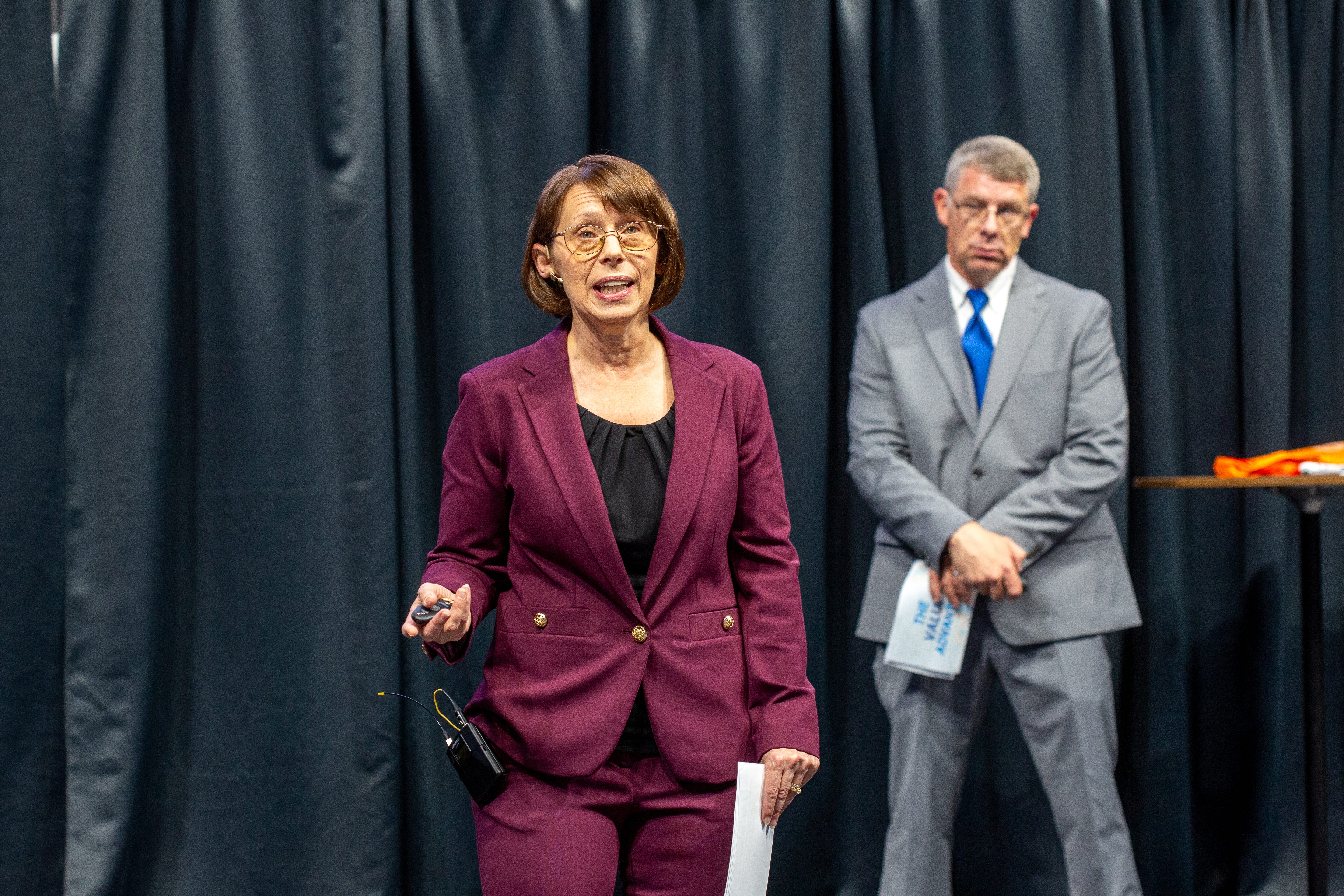 Cindy Dove speaking, with Wes Dove in the background