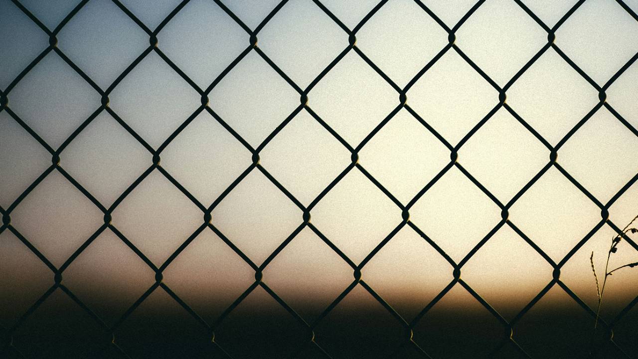 "Rede metálica contra um céu ao entardecer, com luz suave a atravessar as malhas — imagem de destaque do artigo 'Uma Rotina Que Não Aprisiona'"