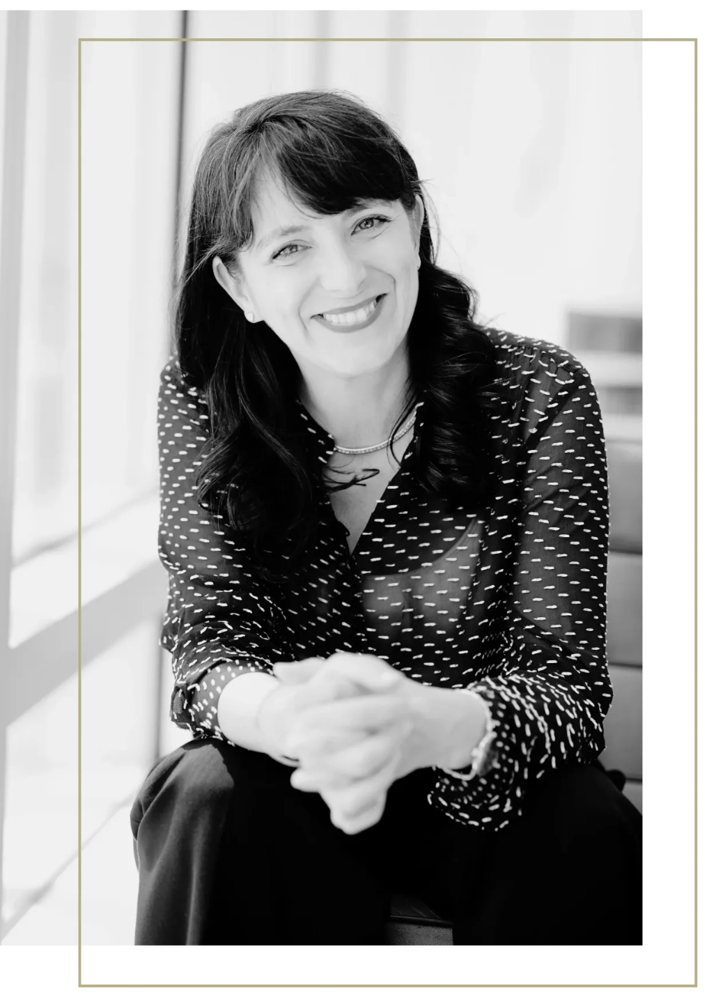 Certified Life and Business Coach Nathalie Pincham standing in front of pink artwork and smiling 