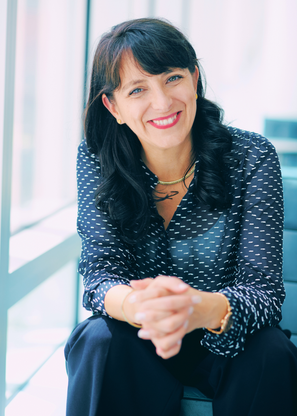 Certified Life and Business Coach Nathalie Pincham standing in front of pink artwork and smiling 