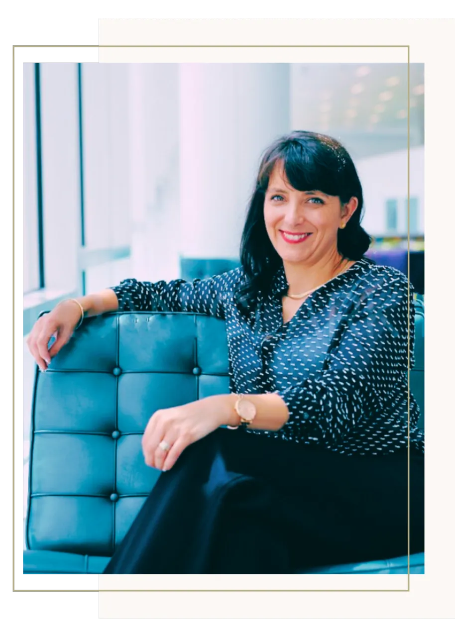 Blue painting resting on gold sofa with a square frame displaying the words Believe in your dreams