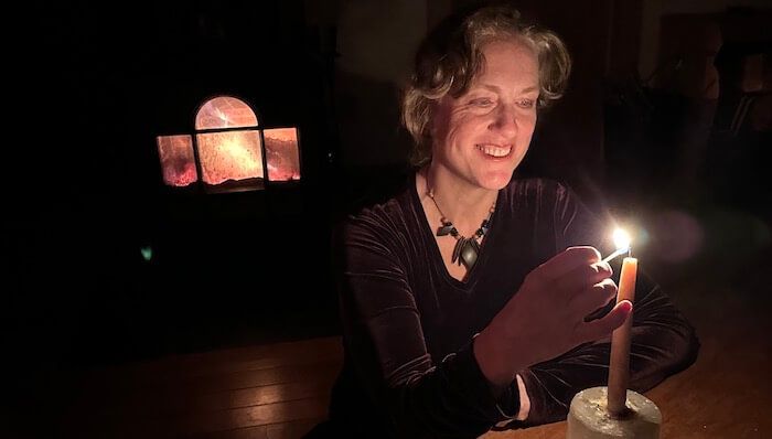 Corinna Wood lighting a candle