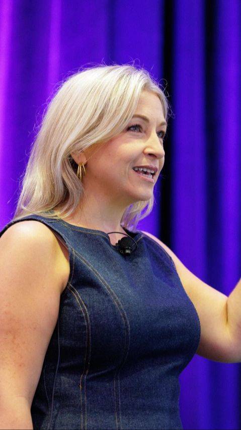 Cassandra Thompson speaking onstage during a keynote.