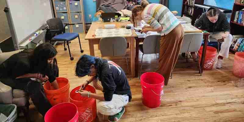 Girls practicing with sandpaper letters