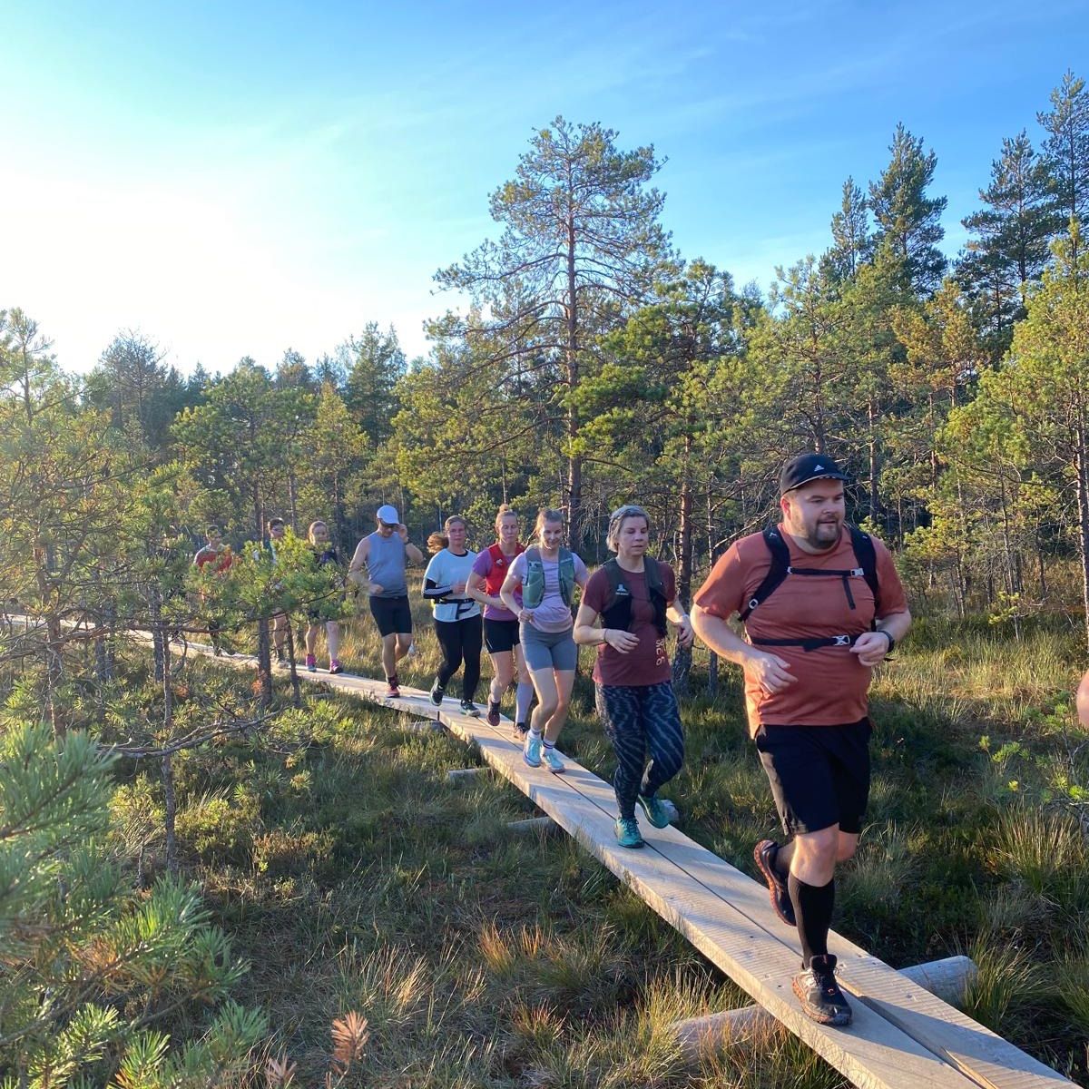 Juoksuryhmä pitkospuilla luonnossa