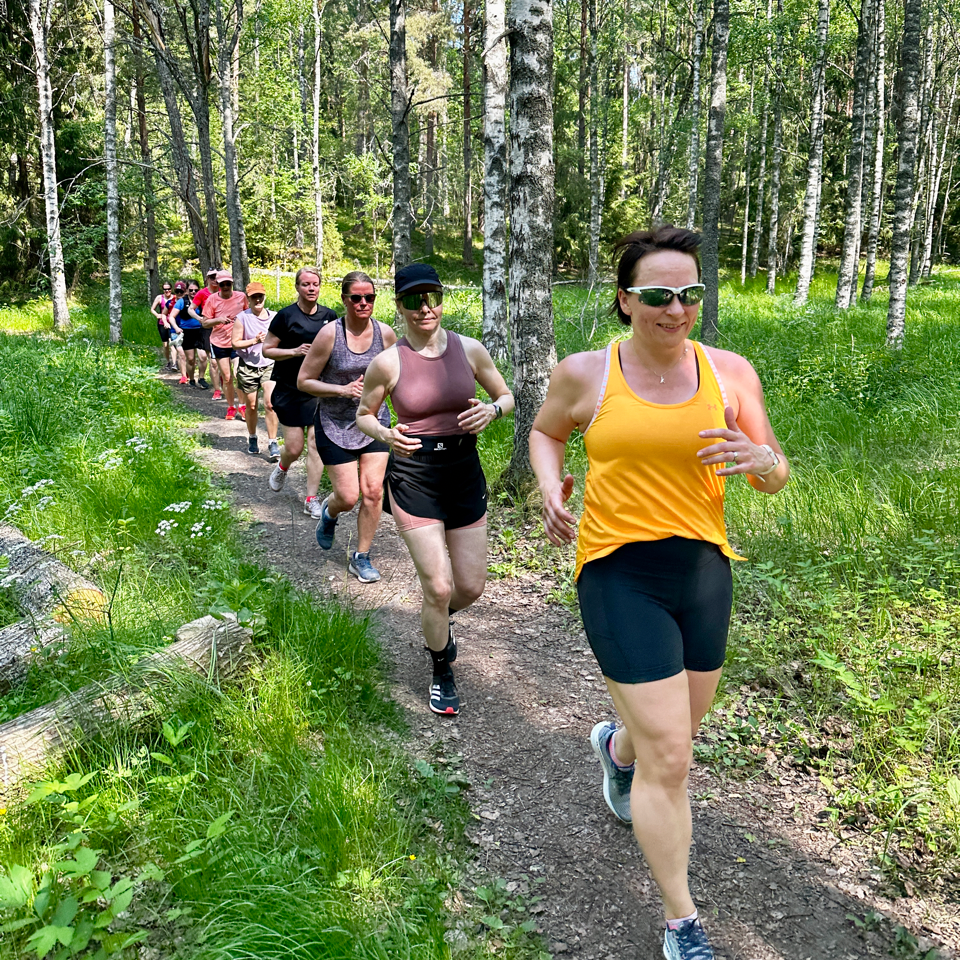 Juoksuryhmä metsäpolulla kesällä