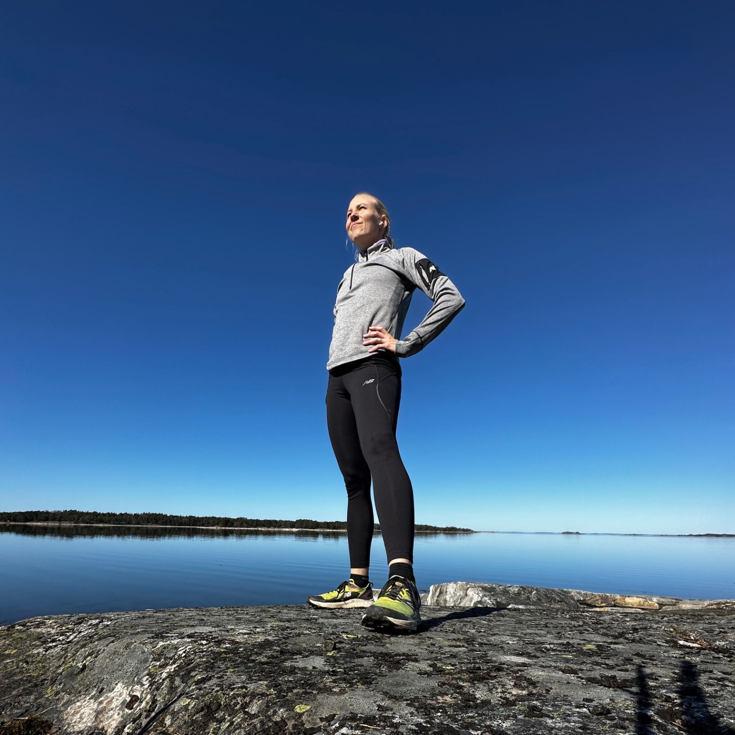 Juoksuvalmentaja kallioilla järvimaisemassa