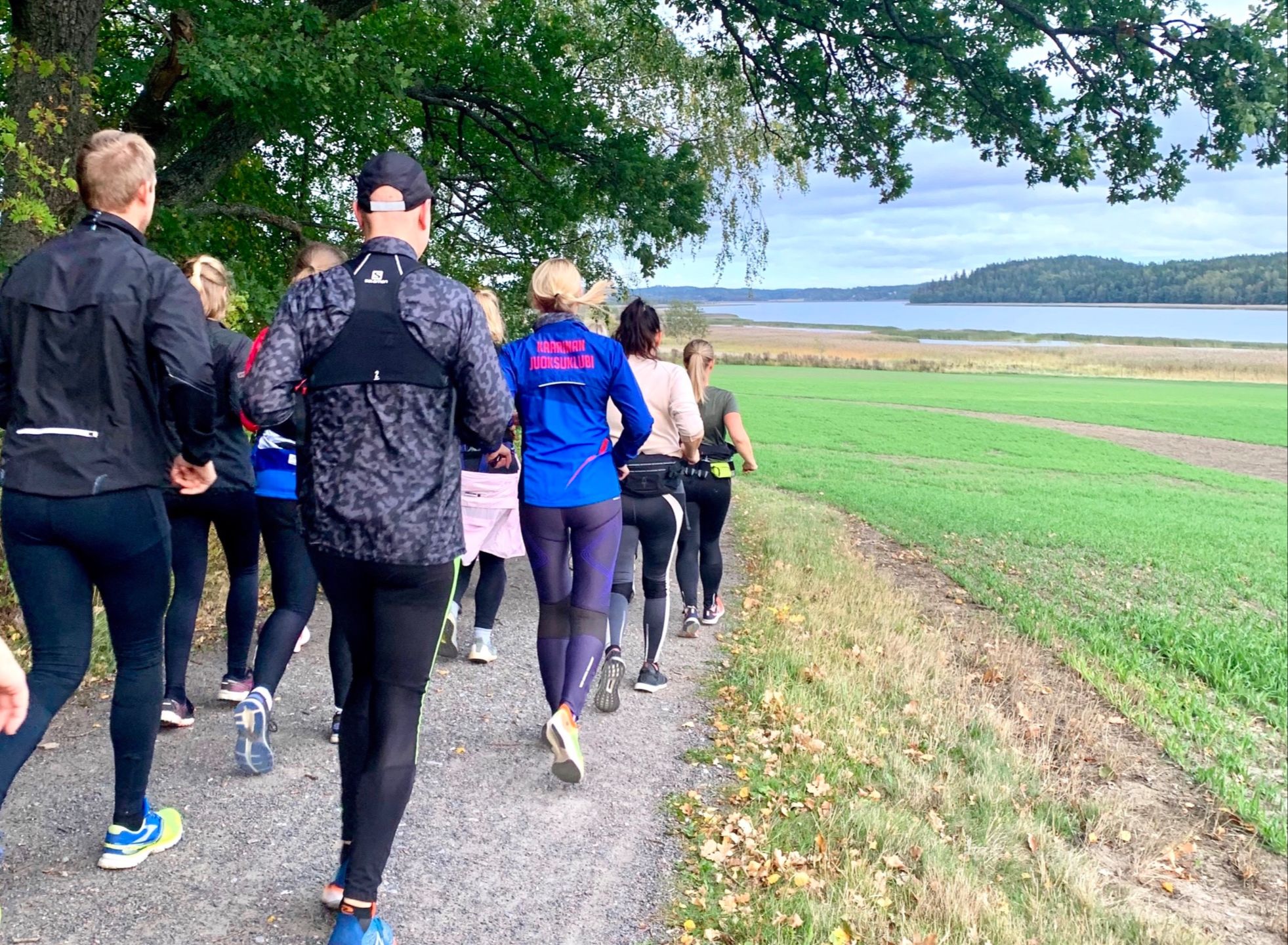 Juoksuryhmä juoksemassa maaseudulla järven rannall