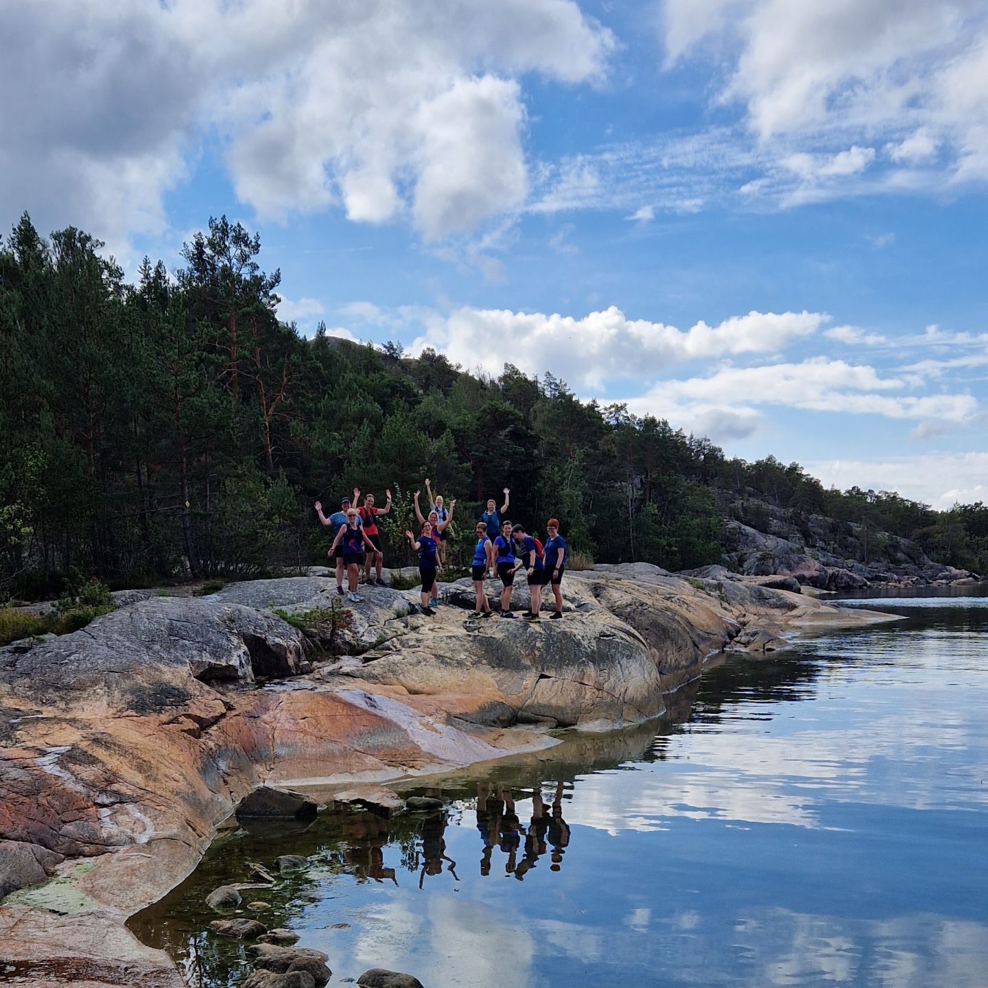 Juoksuryhmä kallioilla järven äärellä