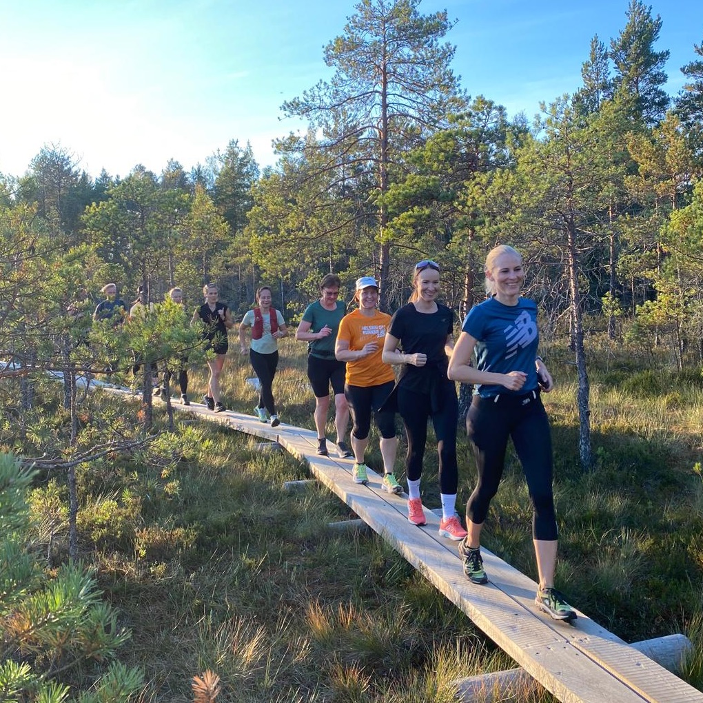 Juoksuklubi pitkospuilla suomaisemassa