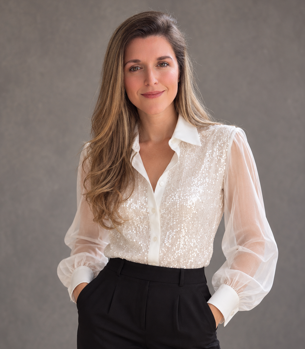 Jennifer Fellin in a white blouse and black trousers against a gray studio background