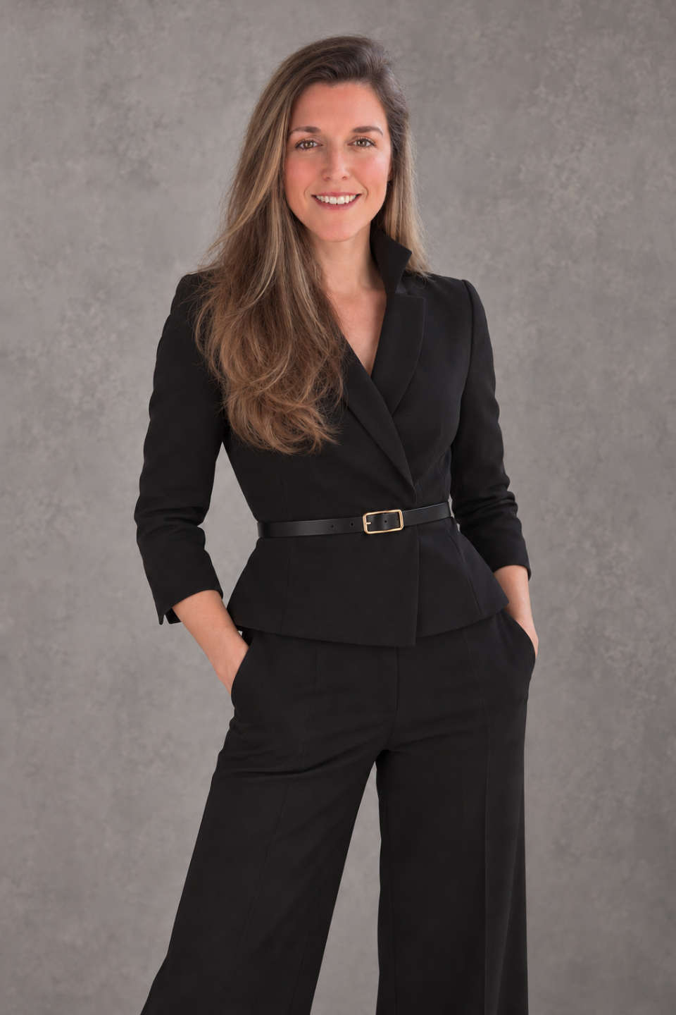 Jennifer Fellin in a tailored black suit against a gray studio background