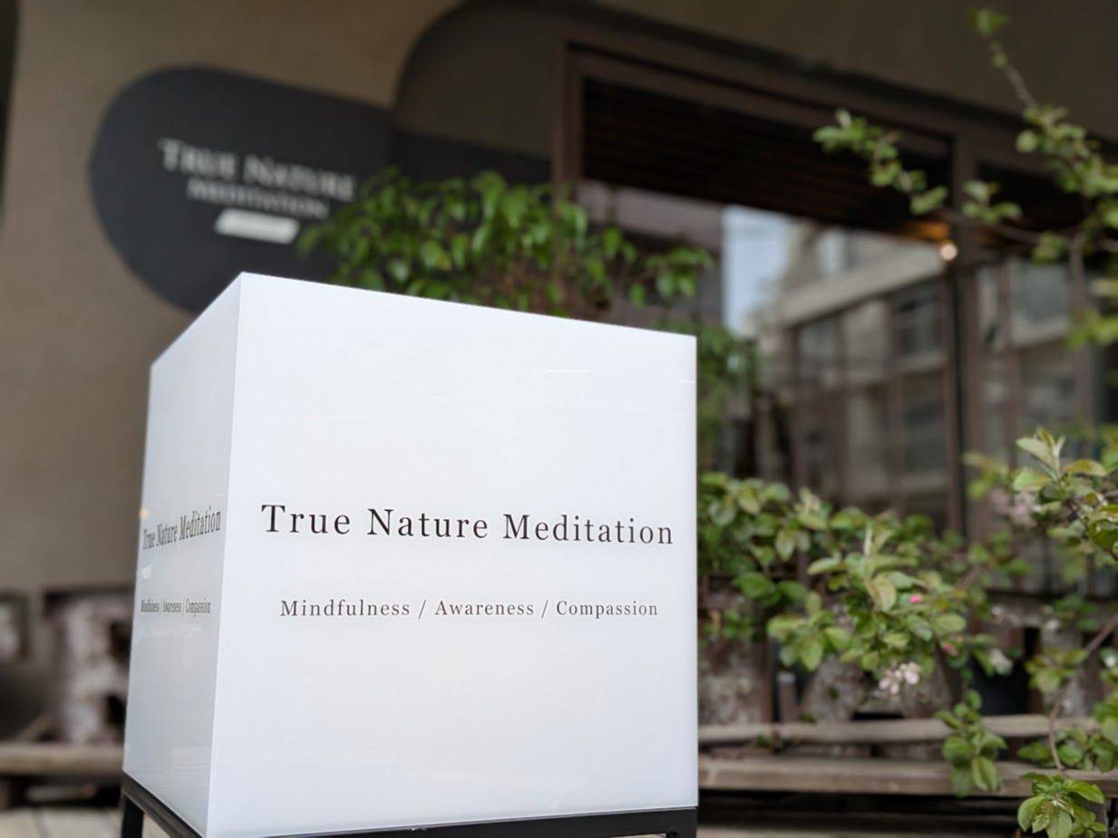 東京・千駄ヶ谷のスタジオ入口——True Nature Meditationのキューブサインと緑