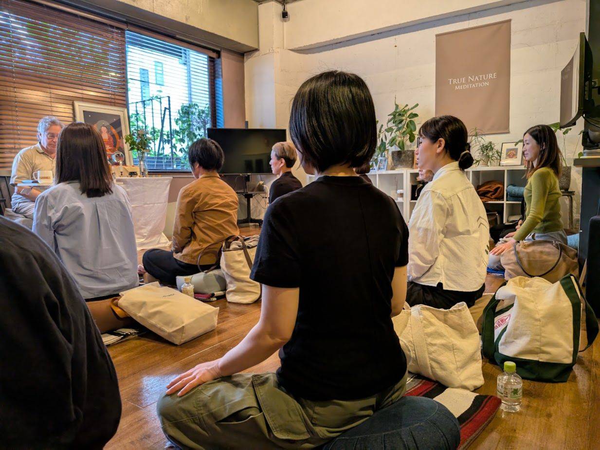 クラス中。前に教師、その後ろに参加者が並んで坐る