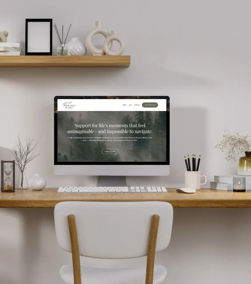 Desktop computer displaying custom Squarespace website design by K+C Creative for service-based business in modern, neutral home office workspace.