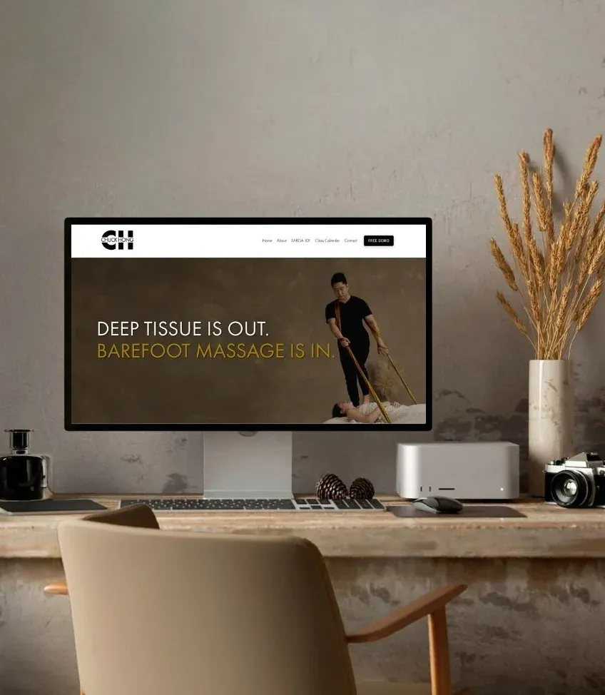Desktop monitor displaying custom website design for barefoot massage therapy business created by K+C Creative in modern office setting.