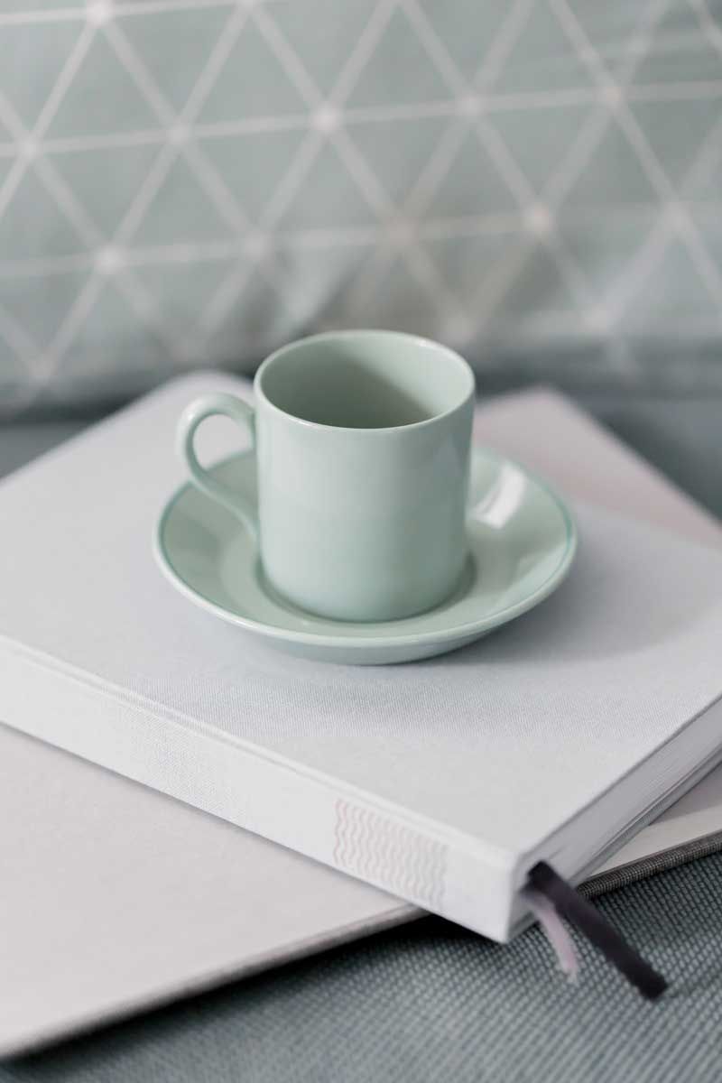 Green coffee cup on stack of books