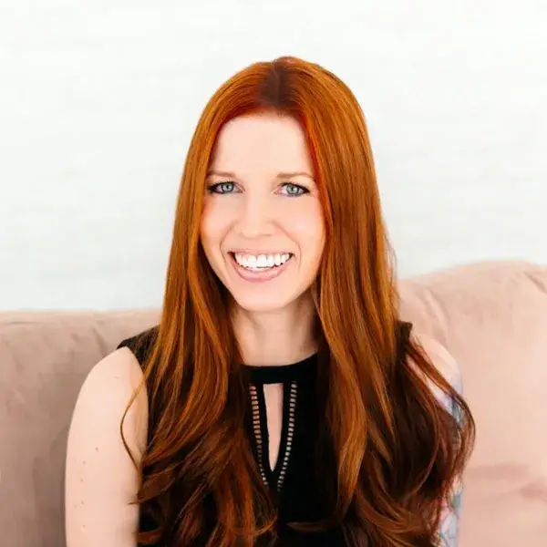 Carrie Howard sitting on a couch smiling
