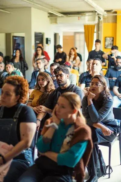 Group of people sitting in large room watching presentation