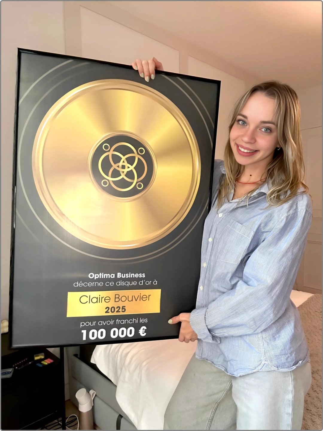 Notre élève Claire se prennant en photo avec son trophée cadeau qui lui a été offert lorsqu'elle à atteint 100 000 euros de résultats financiers