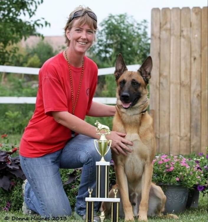 Erica C. Boling, Ph. D kneeling next to a trophy and a dog