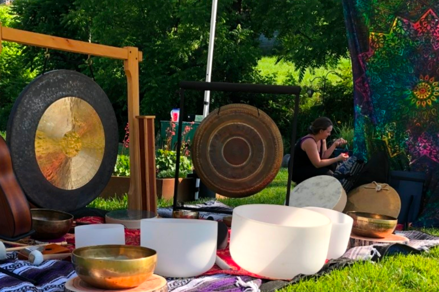 Sound healing practitioner singing on crystal bowls in a room