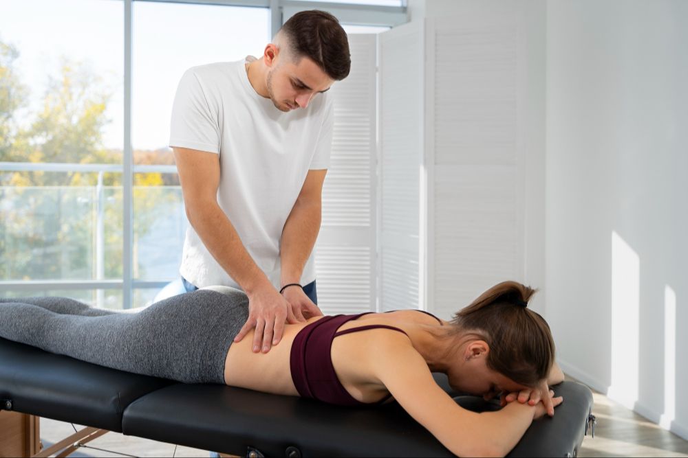 Active adult working one-on-one with physical therapist at Athletes' Potential in Decatur, GA during personalized back pain treatment session