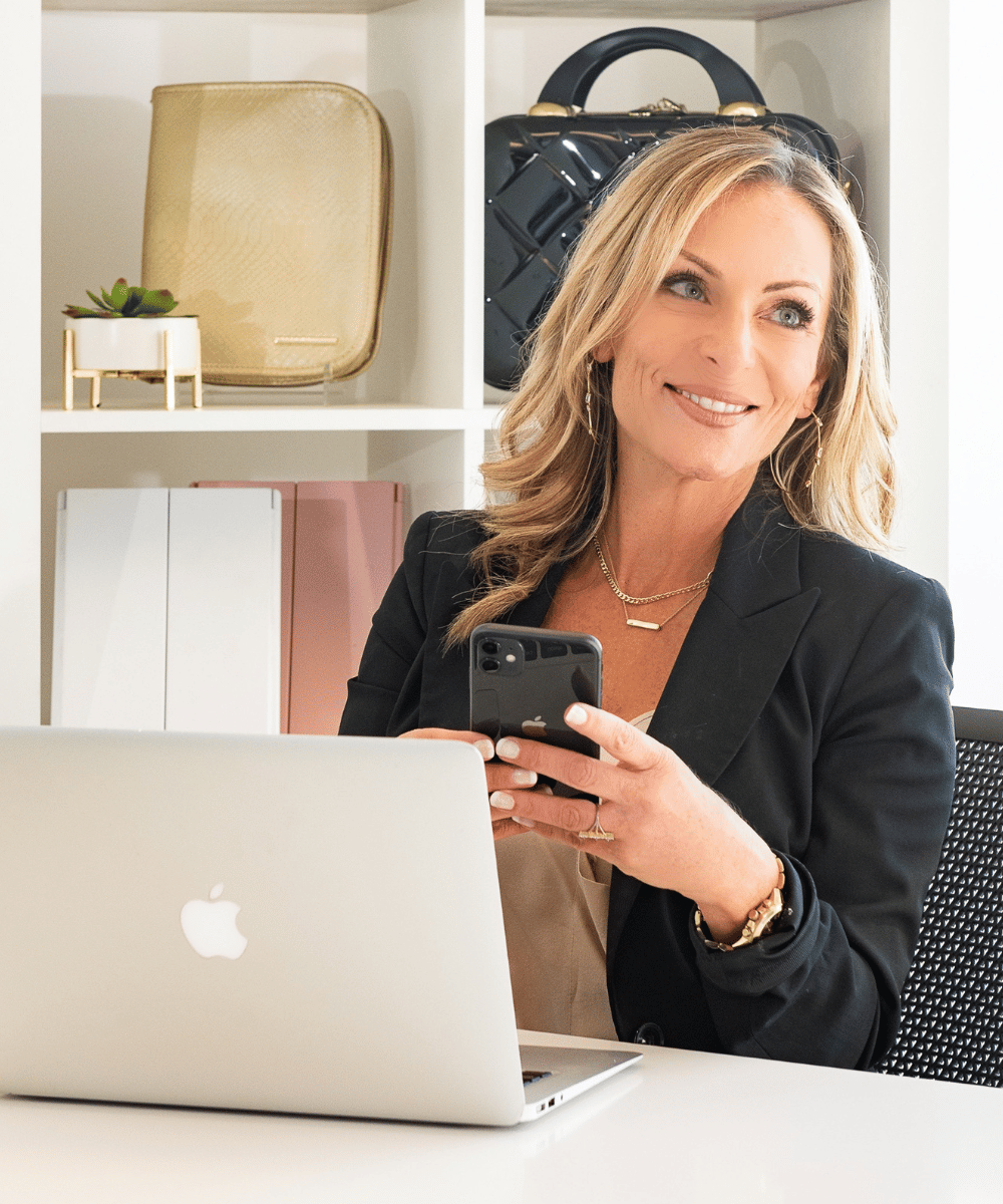 Image of Inventor and Entrepreneur Marcy McKenna sitting in her office with her laptop and cell phone.