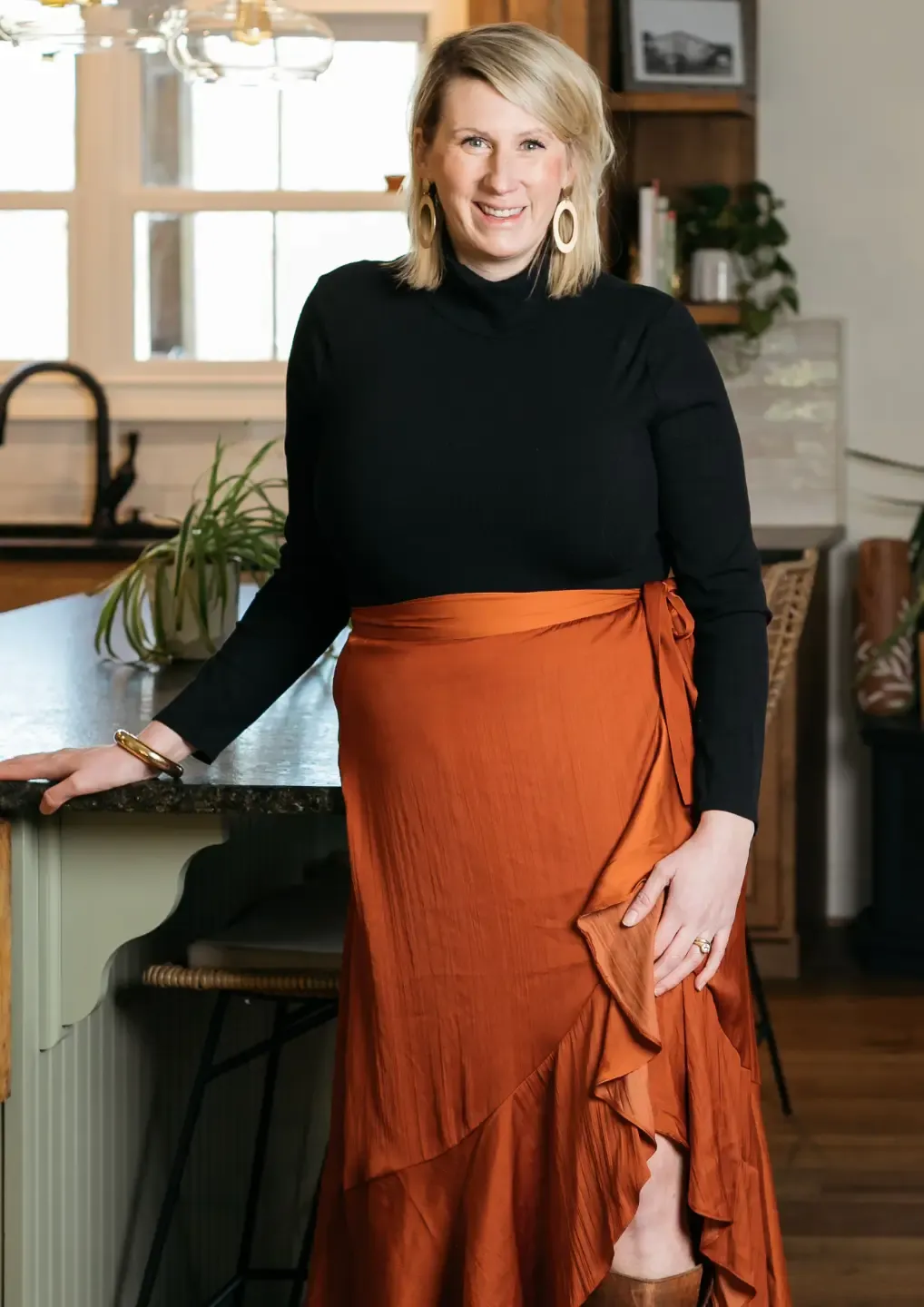 photo of katy poole in a kitchen standing with arm on counter