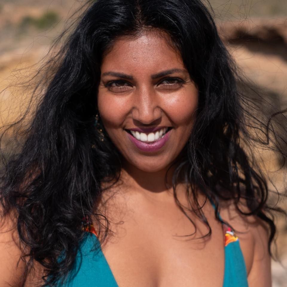 Priya is on a beach, she is enjoying her life.