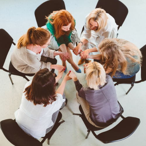 Group of women in a private meeting sitting on chairs in a tight circle
