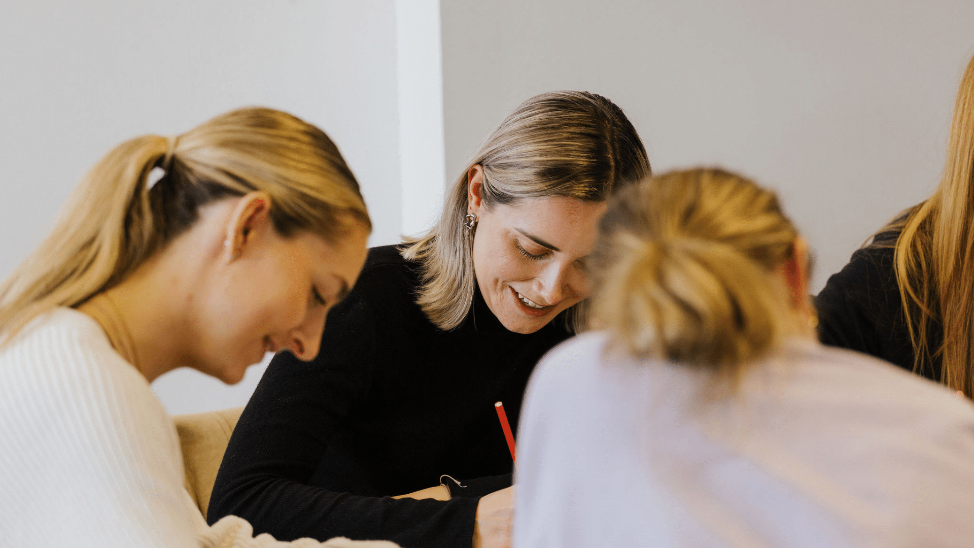 Image of women writing down ideas at a workshop during one of our sessions