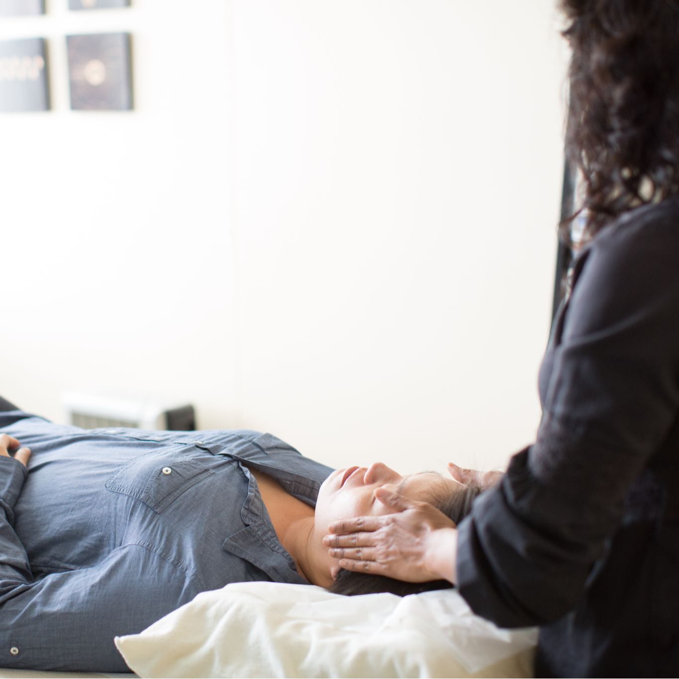 Woman with eyes closed getting thin acupuncture needles placed in points on her face.