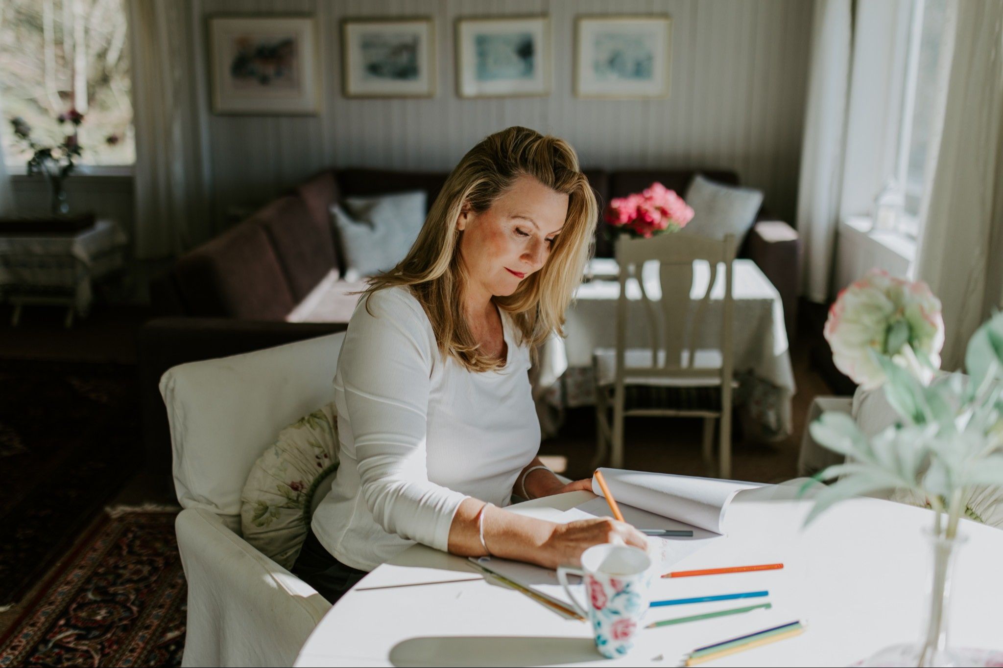 Rita writing at a table in her summer house