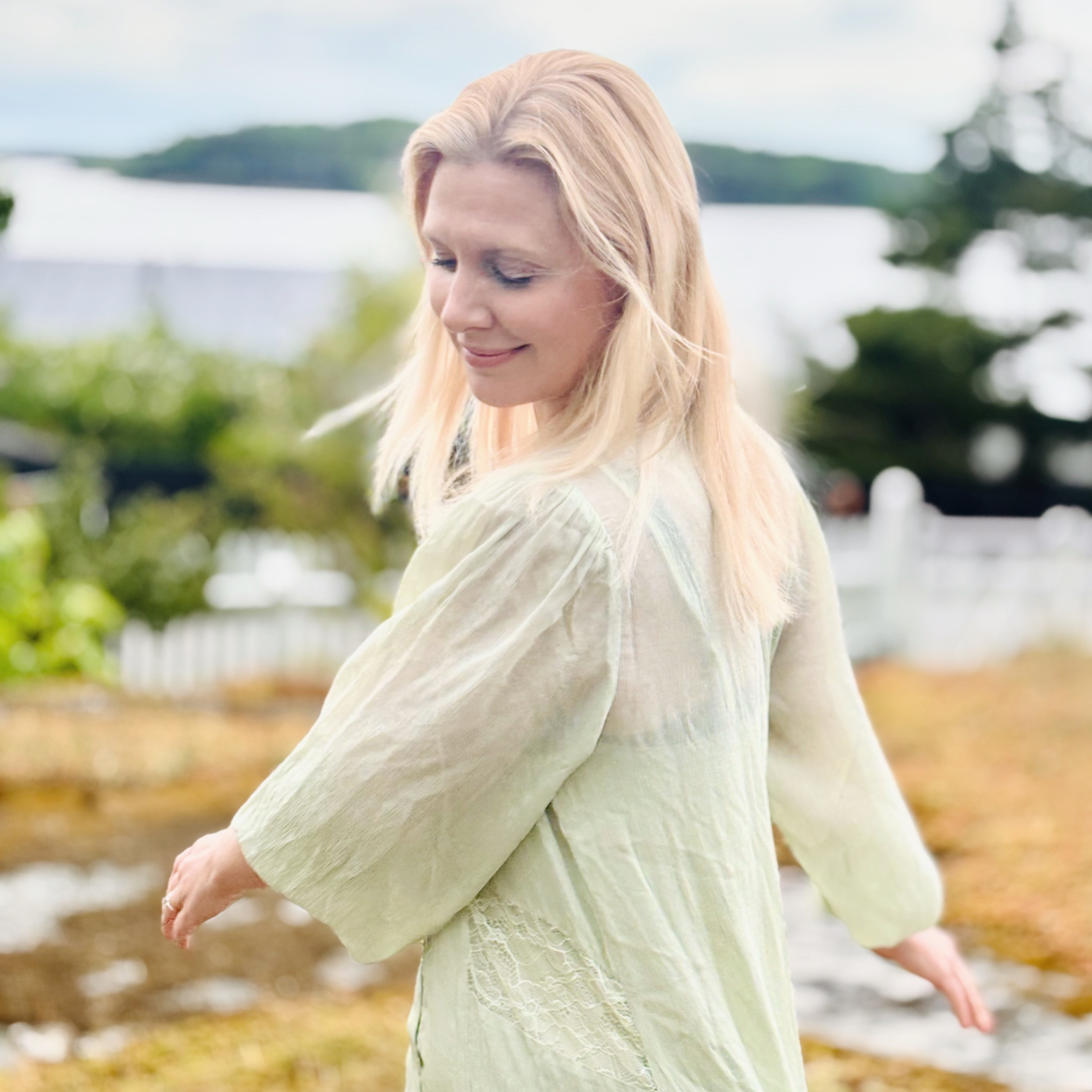 Sofia standing outdoors, swinging her arms side to side, smiling. 