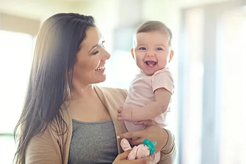 Mother holding smiling baby