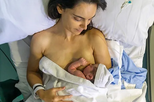 Mother nursing her newborn baby in hospital