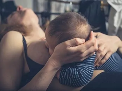 Mother breastfeeding in pain