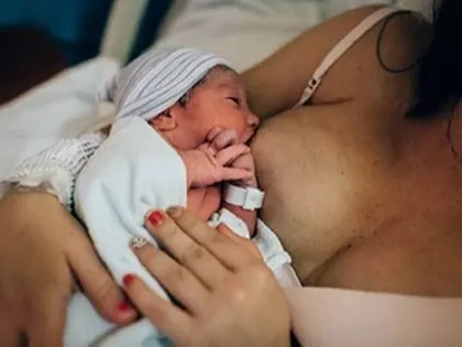 Mother nursing her newborn baby in hospital