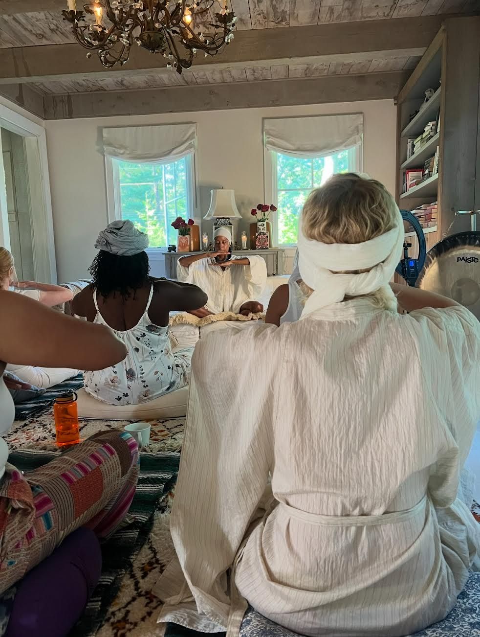 Siri Rishi with two other women with black hats with blossom twigs in front of them